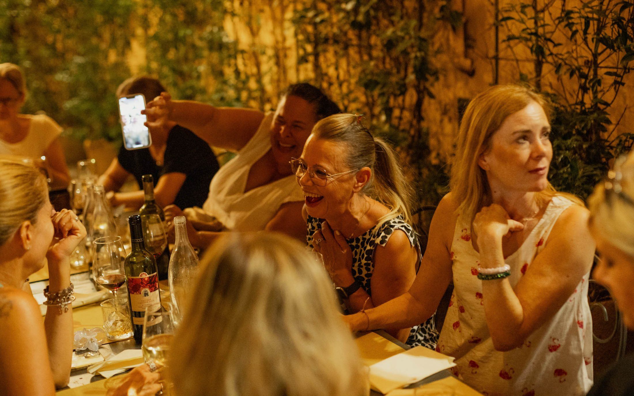 Guests laughing around a dinner table on an evening tour