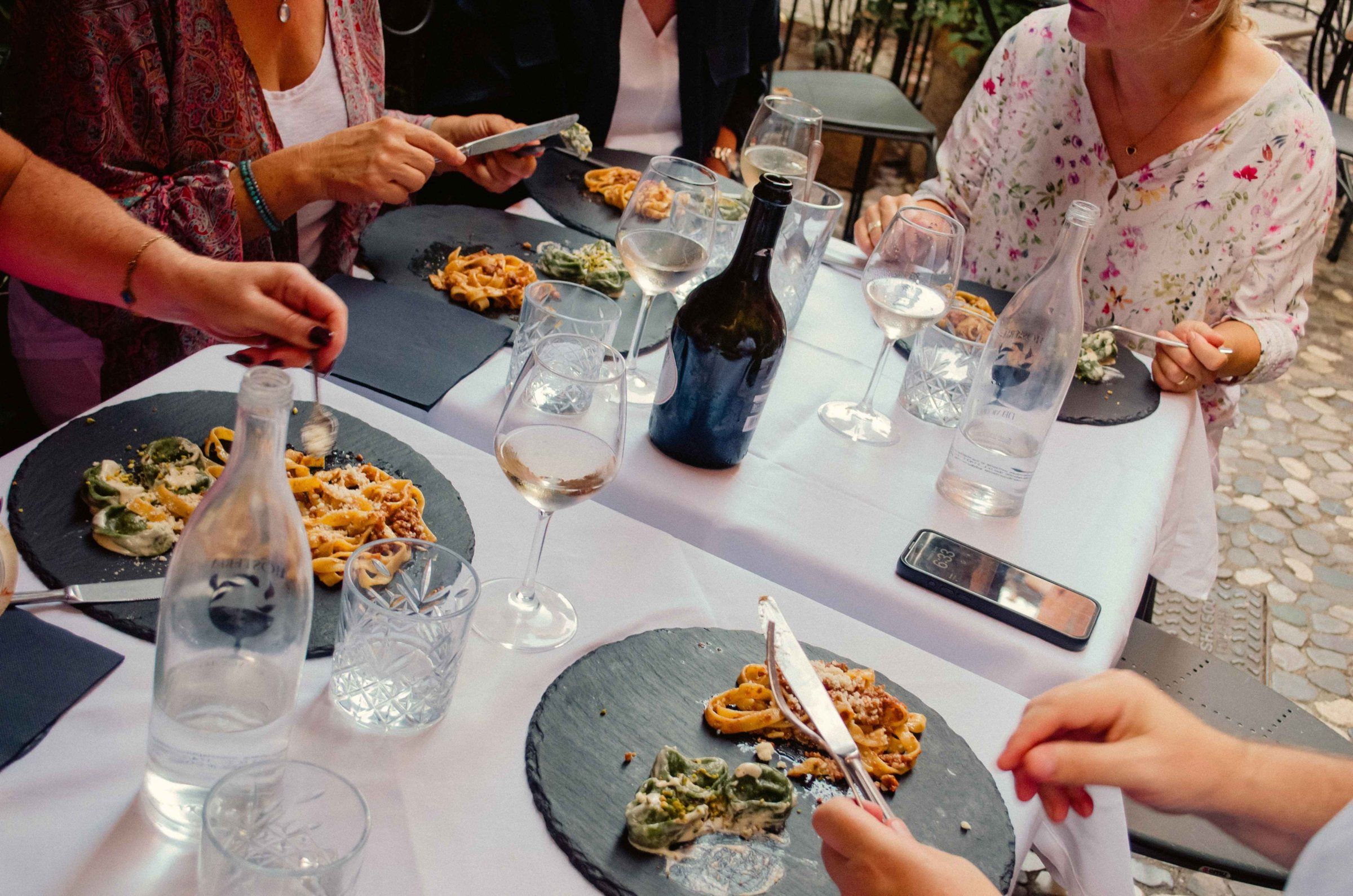 Tagliatelle al ragù and green tortelloni served on slate plates with white wine