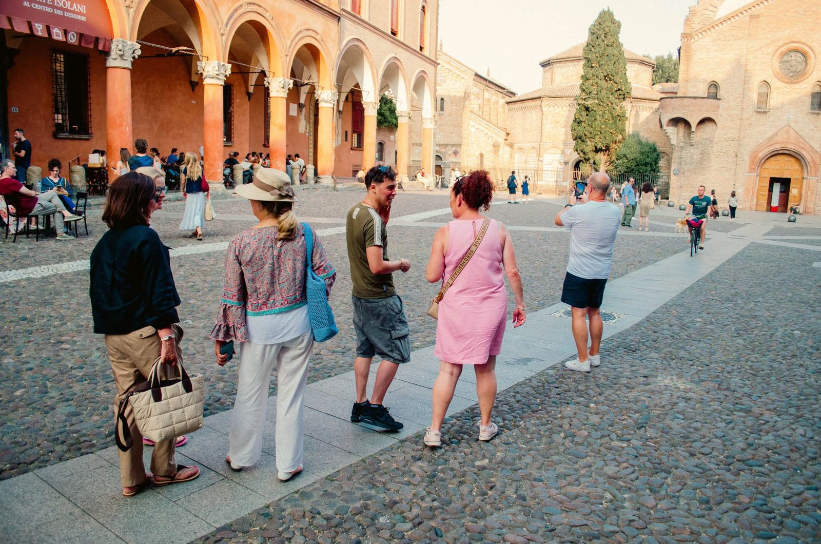 A guide walking a small group across Piazza Santo Stefano in Bologna