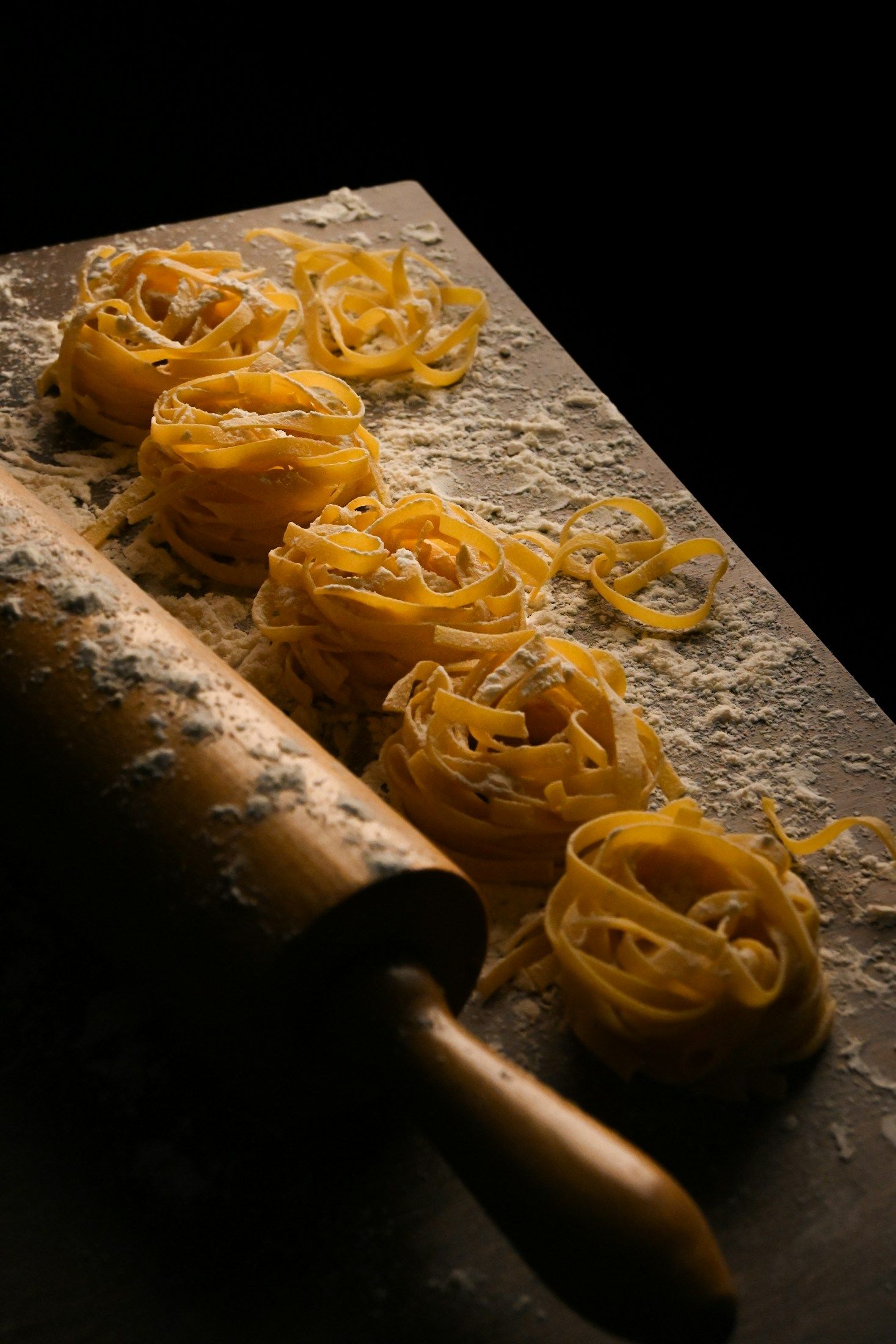 Fresh handmade tagliatelle nests on a wooden board